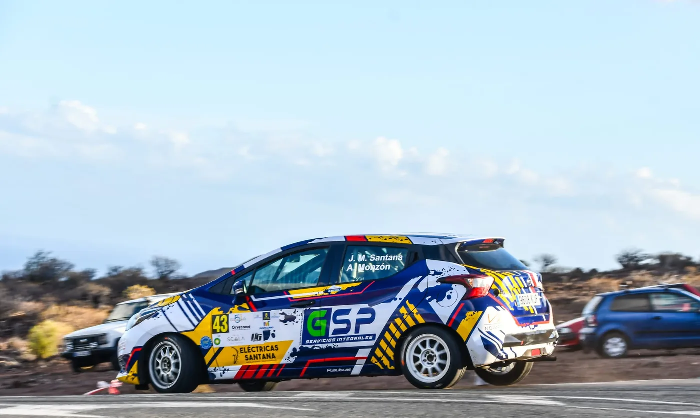 Coche de rally rotulado GSP tomando una curva en carretera de montaña